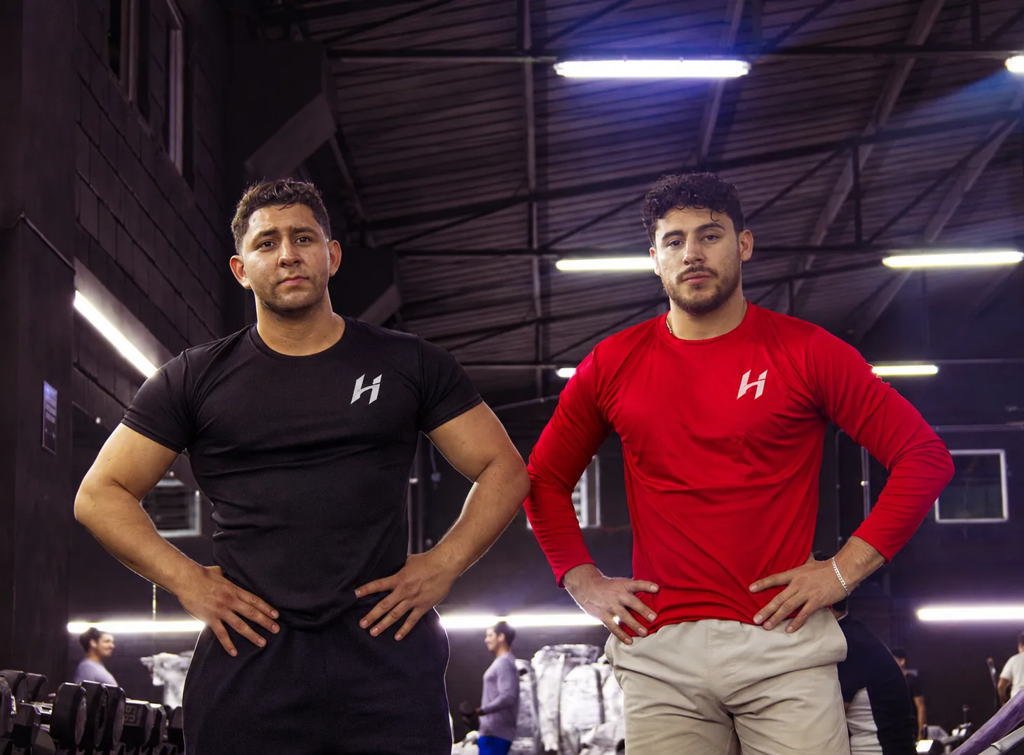 Dos atletas Hustform de pie uno al lado del otro en el gimnasio